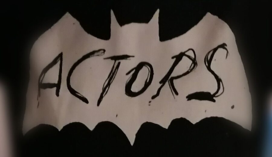 Ein T-Shirt-Aufdruck der Band ACTORS. Das Shirt ist schwarz, der Aufruck ist eine weiße Fledermaus-Silhouette mit der Aufschrift ACTORS. Das Logo ist dem des Batcave-Clubs nachempfunden.