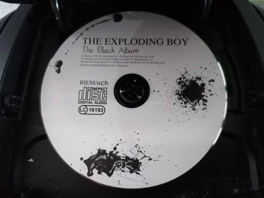 CD "The Black Album" von The Exploding Boy in einem CD-Player.