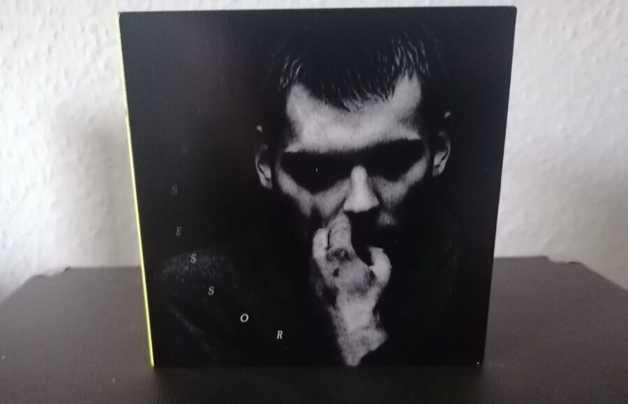 CD "POSSOSSOR" der Band TRAITRS. Das Cover zeigt eine schwarz-weiß-Aufnhme eines Mannes, der sich die rechte Hand an den Mund hält.