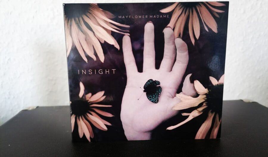 CD "Insight" von Mayflower Madame, das Cover zeigt eine geöffnete Hand, in der ein Schmetterling sitzt. In der vier Ecken sind jeweils Blüten zu sehen.