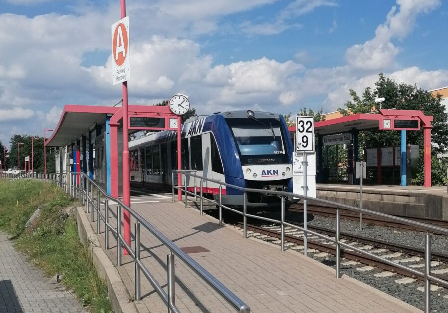 Ein AKN-Zug "Lint 54" in blau, weiß und rot steht an der Haltestelle Kaltenkirchen-Süd.
